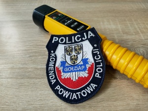 Policyjna naszywka i urządzenie do badania stanu trzeźwości.