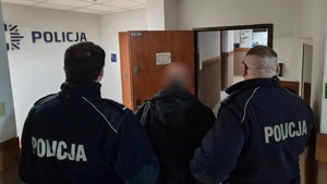 Zatrzymany mężczyzna i policjanci.