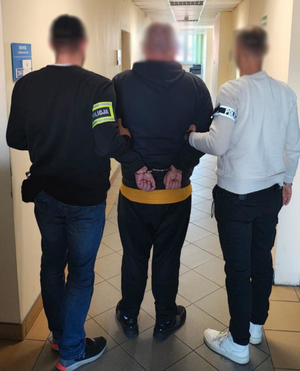 Zatrzymany mężczyzna i policjanci.