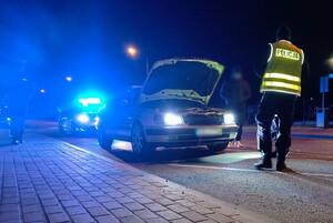 Policjant przy samochodzie podczas kontroli drogowej