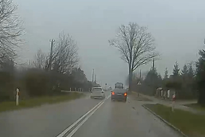 Auto wyprzedza inny pojazd w rejonie przejścia dla pieszych.