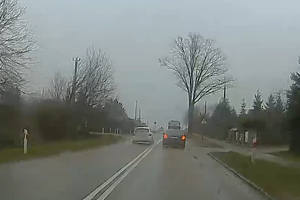 Auto wyprzedza inny pojazd w rejonie przejścia dla pieszych.