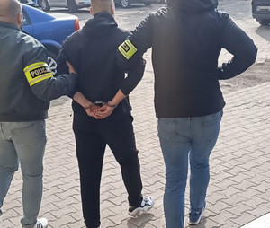 zatrzymany mężczyzna prowadzony przez policjantów