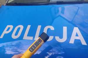 Fragment policyjnego radiowozu i urządzenie do badania stanu trzeźwości.