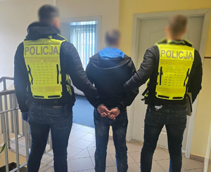 Zatrzymany mężczyzna i policjanci.