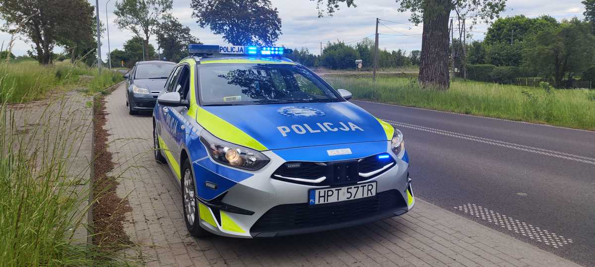 Policyjne auto i pojazd na parkingu