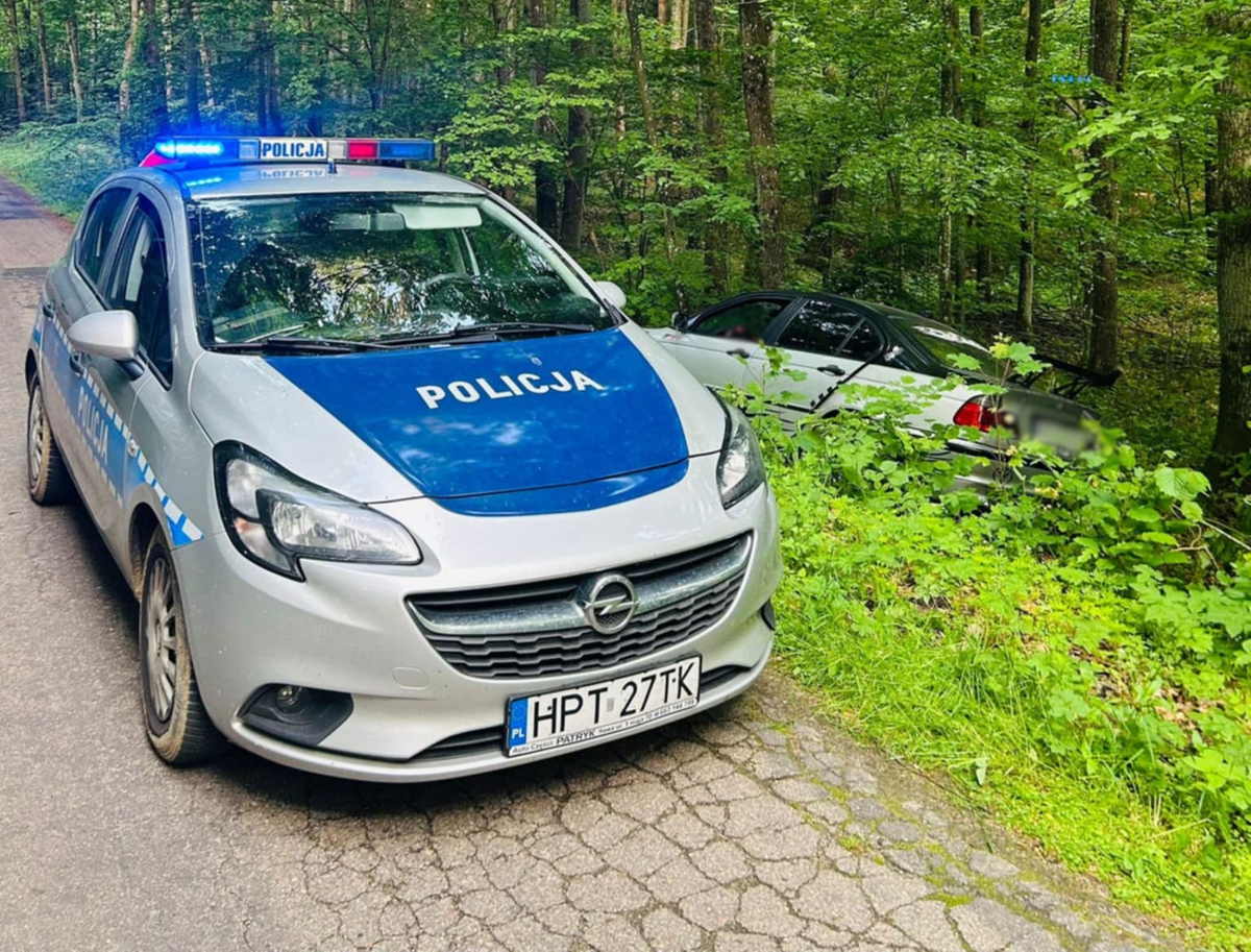 Policyjny radiowóz i auto w rowie