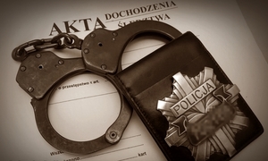 Policyjna legitymacja, kajdanki oraz teczka dochodzeniowo-śledcza
