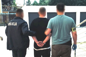 Zatrzymany mężczyzna prowadzony przez policjantów