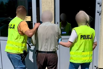 Zatrzymany mężczyzna prowadzony przez policjantów