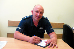 aspirant sztabowy Grzegorz Gąsior za biurkiem