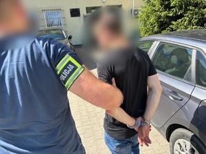 Zatrzymany mężczyzna prowadzony przez policjantów
