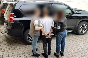 Zatrzymany mężczyzna prowadzony przez policjantów