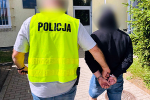 Zatrzymany mężczyzna prowadzony przez policjanta