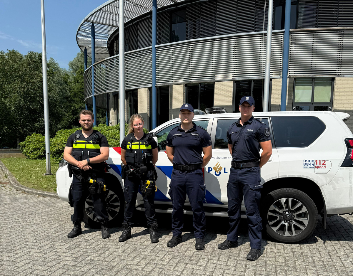 Policjanci na tle radiowozu