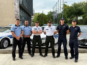 Policjanci na tle radiowozu