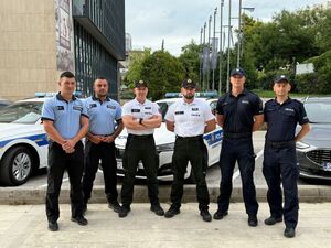 Policjanci na tle radiowozu
