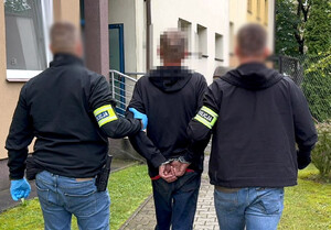 Zatrzymany mężczyzna prowadzony przez policjantów