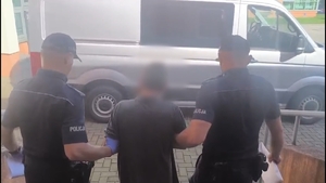 zatrzymany prowadzony przez policjantow