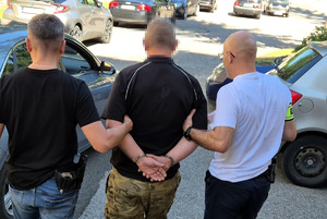Zatrzymany mężczyzna prowadzony przez policjantów