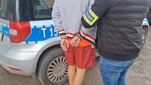 Zatrzymany mężczyzna prowadzony przez policjanta