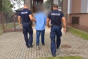 Zatrzymany mężczyzna prowadzony przez policjantów