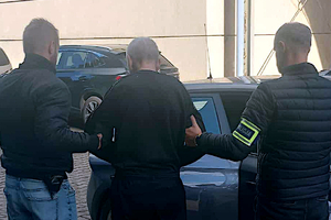 Zatrzymany mężczyzna prowadzony przez policjantów