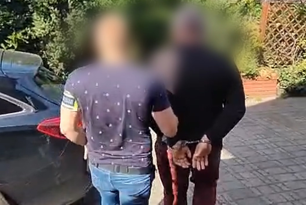 Zatrzymany mężczyzna prowadzony przez policjanta