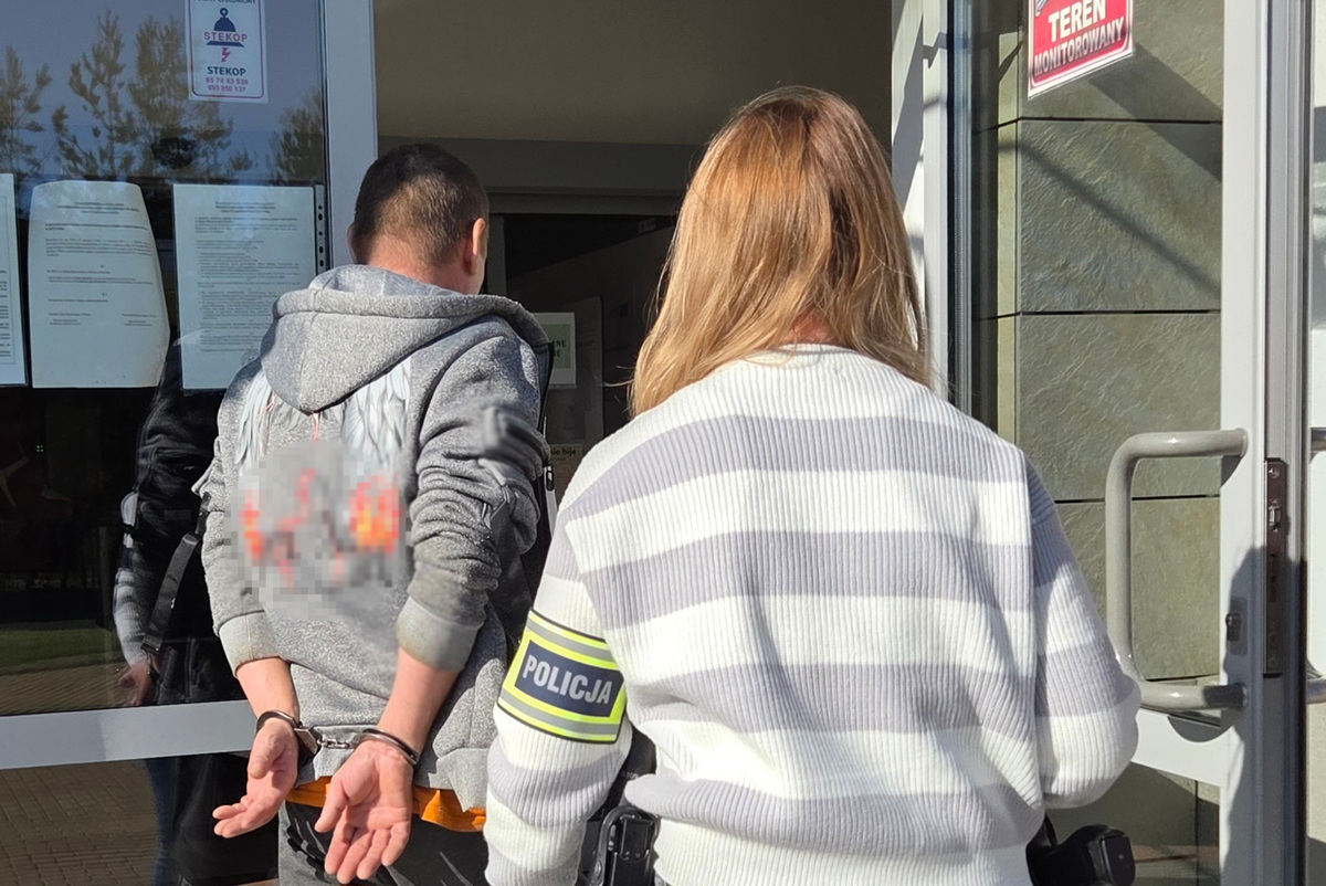 Zatrzymany mężczyzna prowadzony przez policjantkę