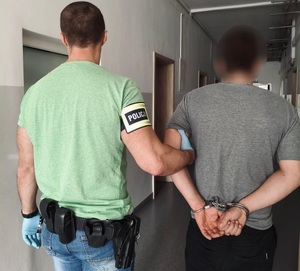 policjant prowadzi zatrzymanego