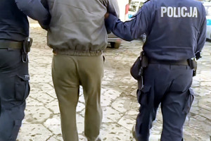 Zatrzymany mężczyzna prowadzony przez policjantów