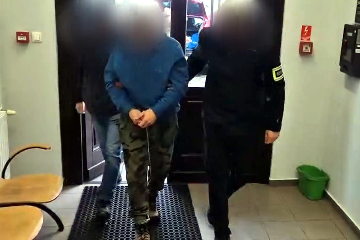 Zatrzymany mężczyzna prowadzony przez policjantów