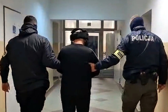 Zatrzymany mężczyzna prowadzony przez policjantów