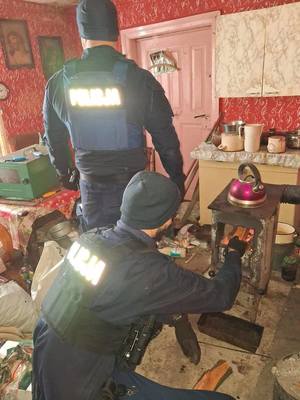 Policjanci rozpalający w piecu