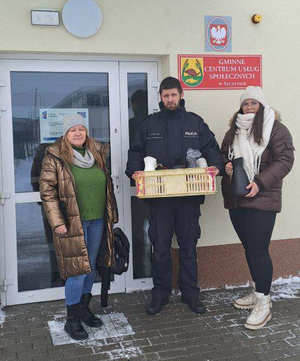 Policjant i kobiety przed budynkiem