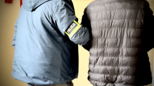 Zatrzymany mężczyzna prowadzony przez policjanta