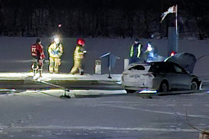 Rozbity samochód przy pomoście na zamarzniętym jeziorze