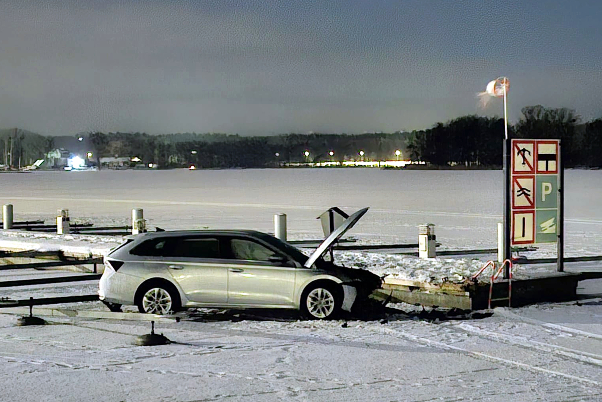 Rozbity samochód przy pomoście na zamarzniętym jeziorze