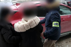 Zatrzymana kobieta prowadzona przez policjantów