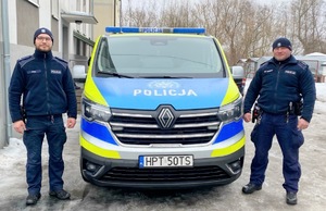 policjanci stojący przy radiowozie