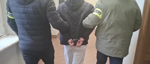 zdjęcie przedstawia doprowadzenie osoby zatrzymanej