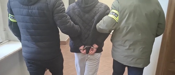 zdjęcie przedstawia doprowadzenie osoby zatrzymanej