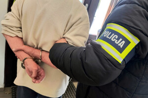 Zatrzymany mężczyzna prowadzony przez policjantów