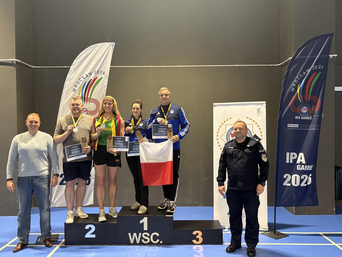 Uczestnicy zawodów na podium z flagą