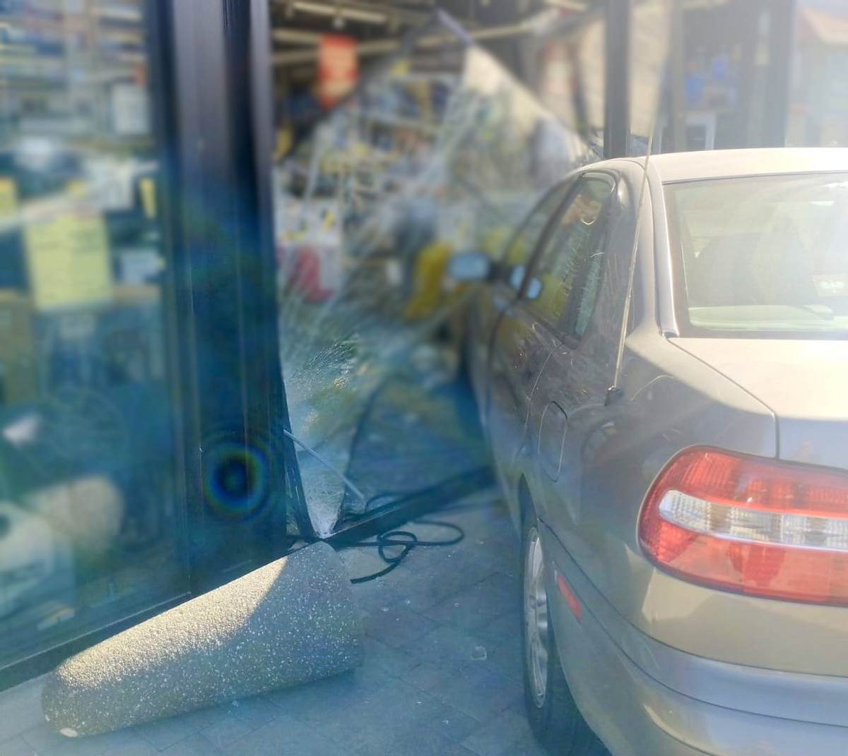 Uszkodzone auto i fragment budynku