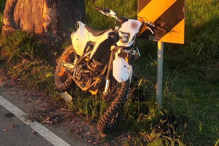 Uszkodzony motocykl oparty o znak drogowy
