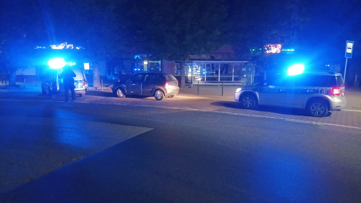 Noc, radiowozy z uruchomionymi światłami uprzywilejowania, policjanci prowadzą czynności na miejscu