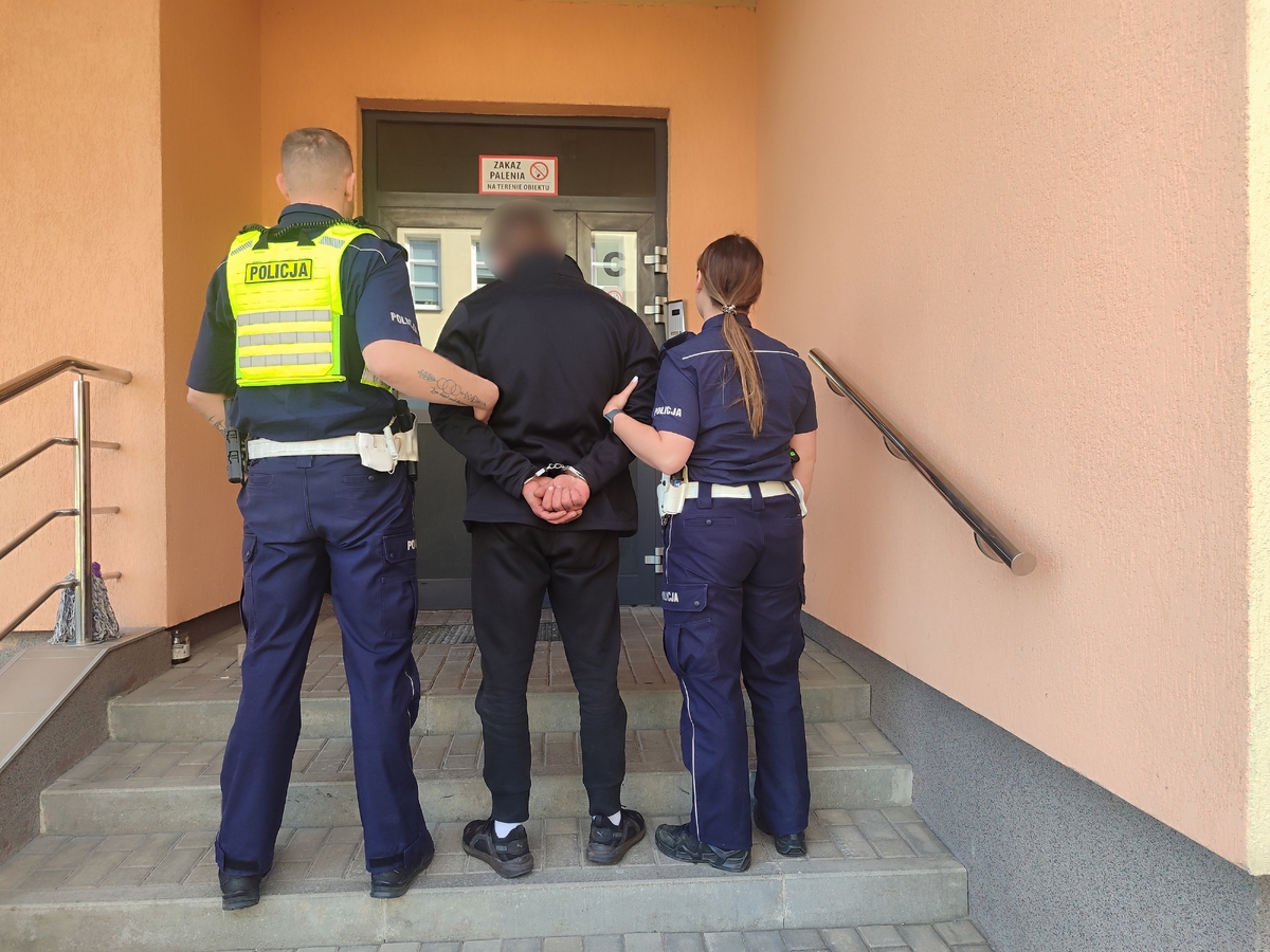 Policjanci ruchu drogowego podczas doprowadzenia zatrzymanego mężczyzny