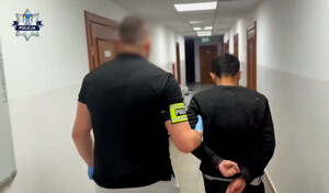 Zatrzymany mężczyzna prowadzony przez policjanta