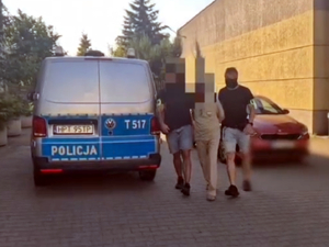 Zatrzymany mężczyzna prowadzony przez policjantów